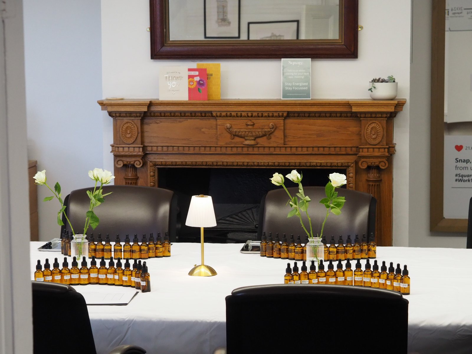 An OZORNINA perfume workshop table set with fragrance ingredients, white roses and lamps