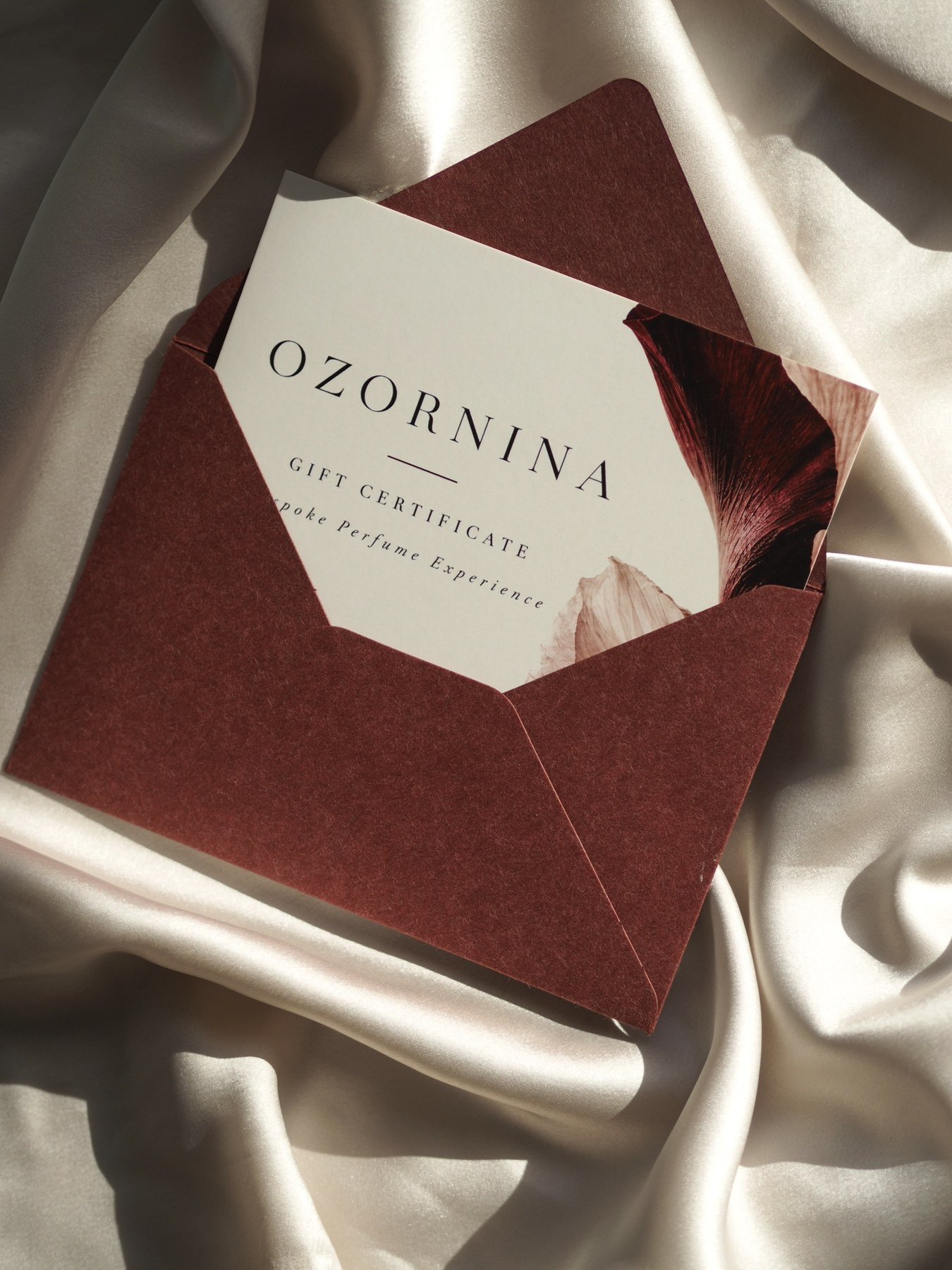 OZORNINA gift certificate in a burgundy envelope on ivory silk